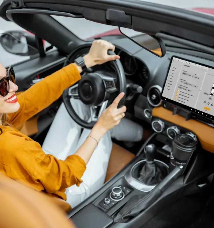 woman driving sports car with a digital touchscreen e1650945595436.jpg